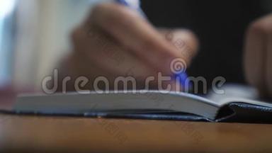 人在笔记本上写字.. 男人`手生活方式写在记事本上。 概念商业教育。 1.男人在房间里做笔记